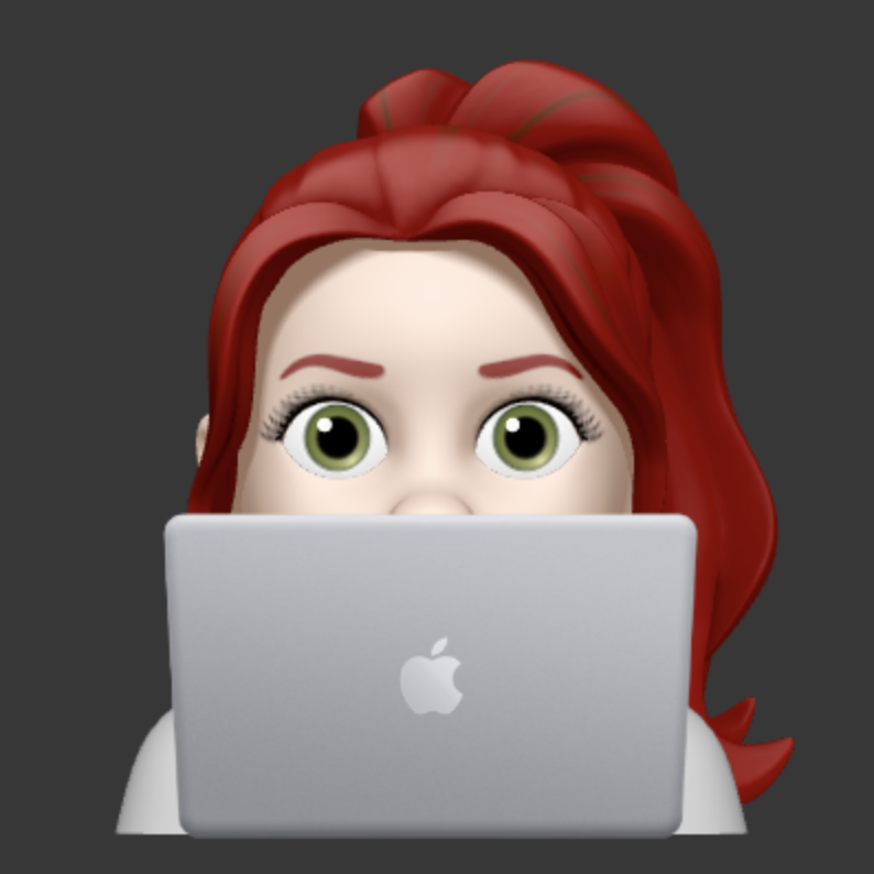 a redhead woman with a ponytail behind a laptop computer